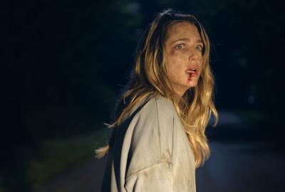 A bloody faced Ellie looks back