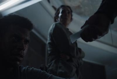 A person hands a man on the ground a note.