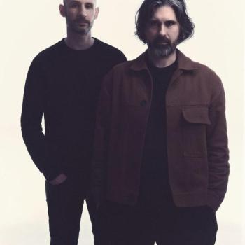 Two men stand glaring at the camera while they think about conquering the world